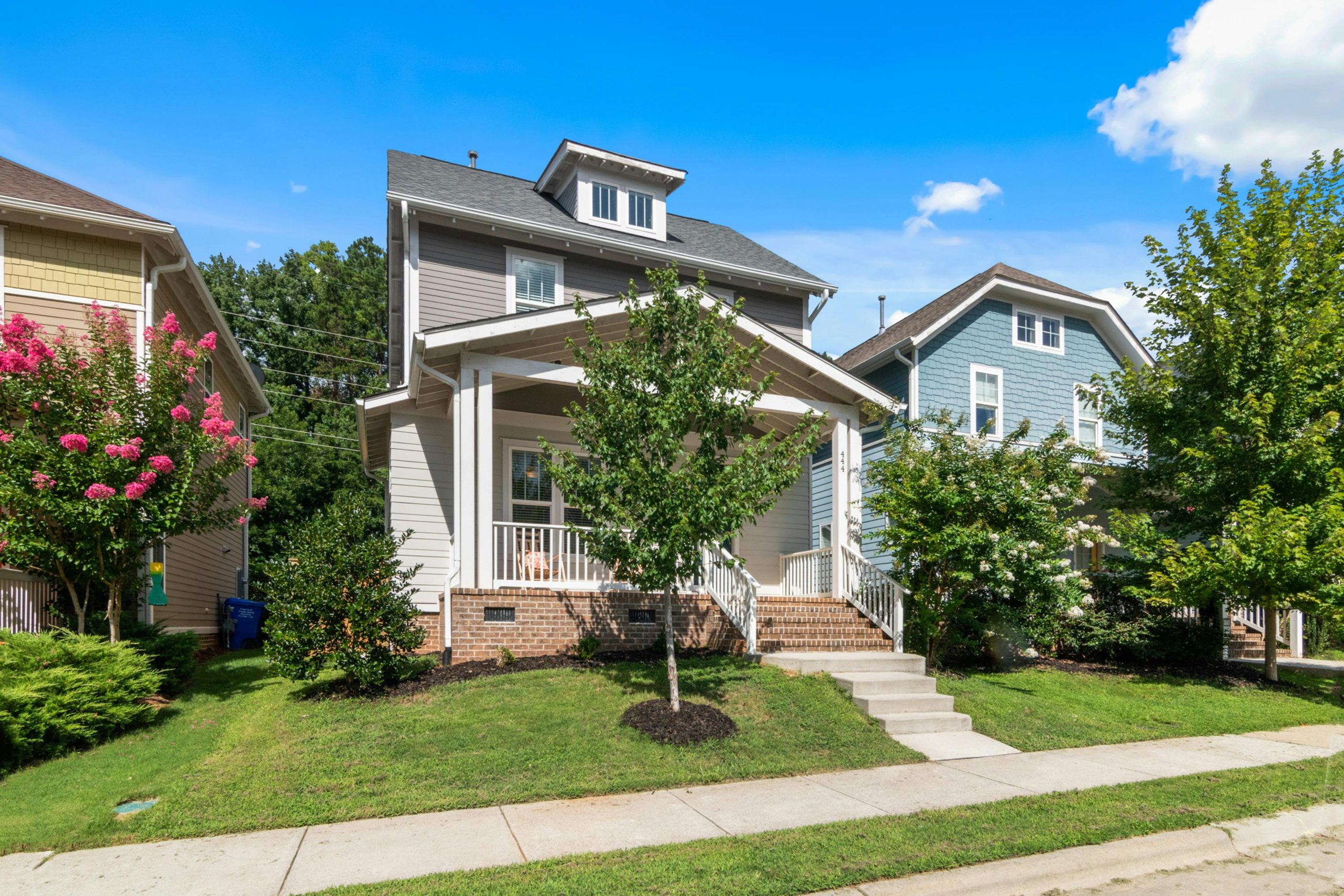 Beautiful suburban home with lush greenery and clear blue sky.
